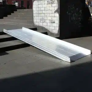 Aluminium-Rampe zur Überwindung von Stufen, für barrierefreien Zugang, auf einem Gehweg platziert.